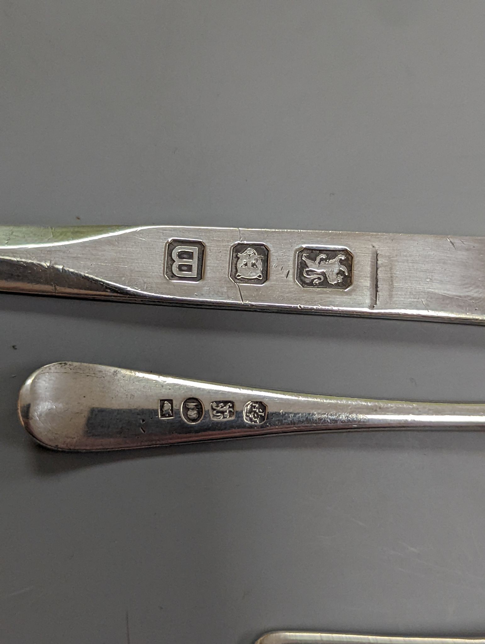 A George VI silver paper knife, London, 1937, a plated toddy ladle, two pairs of silver sugar tongs, damaged silver fruit knife and two other items.